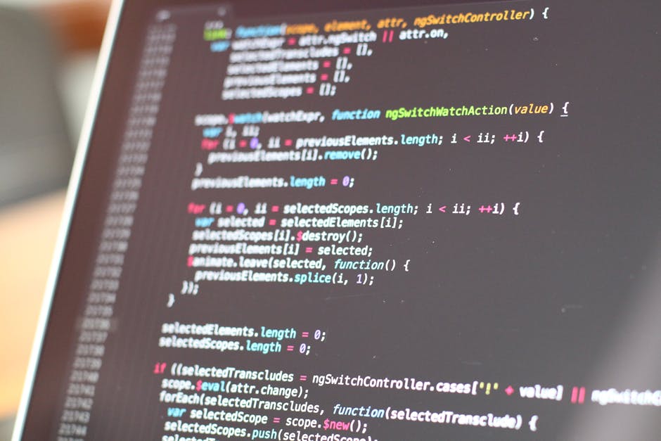 Close-up image of a computer screen displaying colorful programming code in various text colors such as orange, pink, green, and yellow on a dark background. The code includes syntax elements like 're